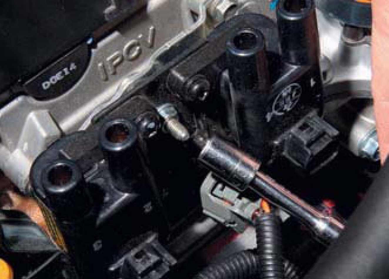 Отворачивание верхней гайки крепления кронштейна катушек зажигания к кронштейну головки блока цилиндров двигателя F16D3 Daewoo Nexia N150