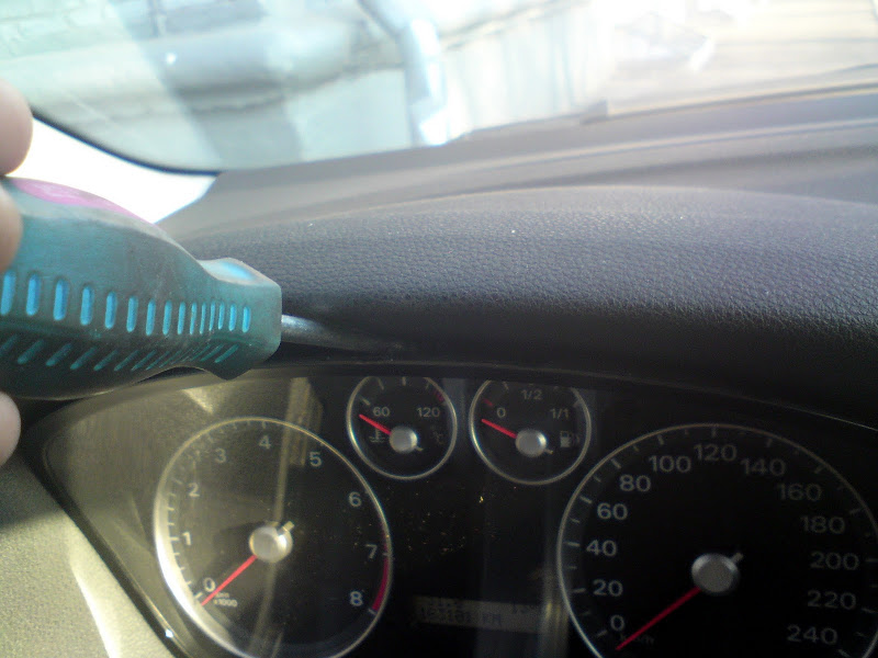 Вставляем плоскую отвертку по центру приборки Ford Focus 2