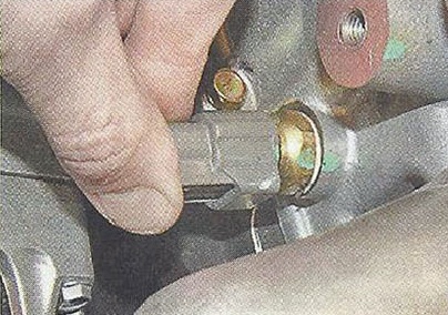 Нажимаем на фиксаторы колодок жгута проводов и отсоединяем колодки от датчика температуры охлаждающей жидкости Nissan Primera
