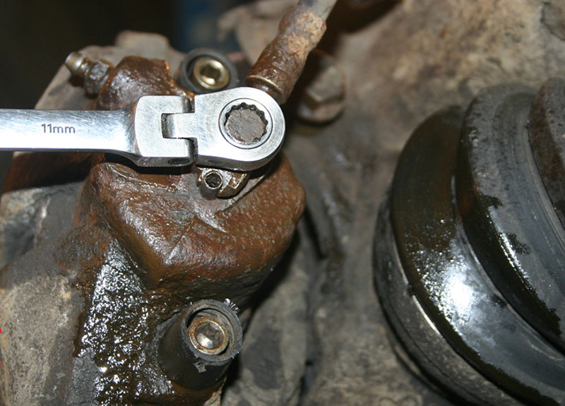 Откручивание полого болта фиксирующего шланг тормозного механизма Volkswagen Passat B6 2005-2010