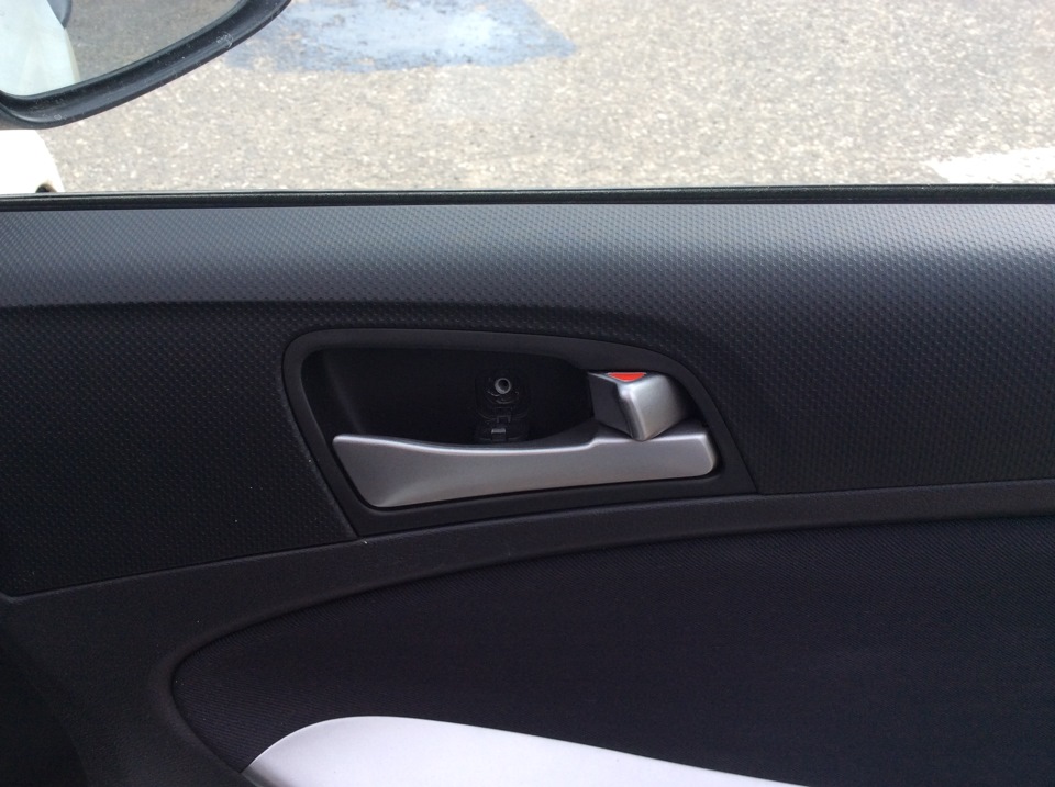 Крестообразной отвёрткой отворачиваем саморез крепления декоративной накладки панели двери на автомобиле Hyundai Solaris