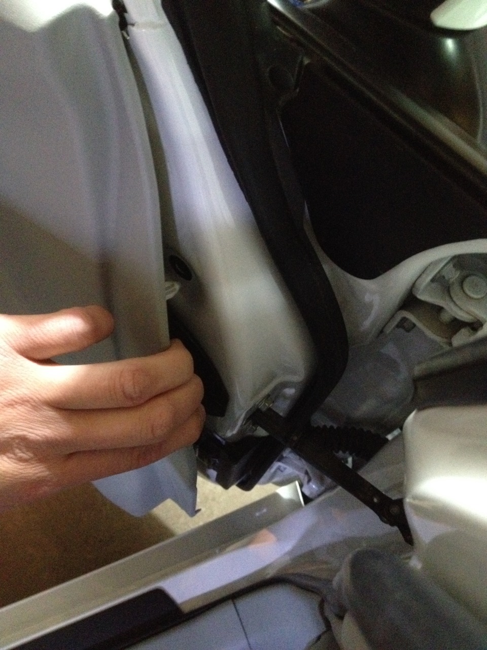 Потянув за край обивки отделяем обивку двери на автомобиле Hyundai Solaris