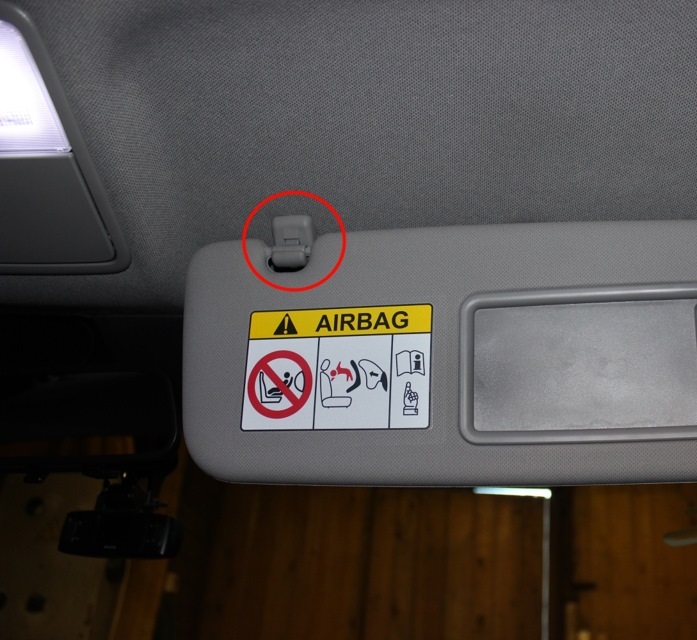 Выведите проушину козырька из зацепления с крючком на автомобиле Hyundai Solaris