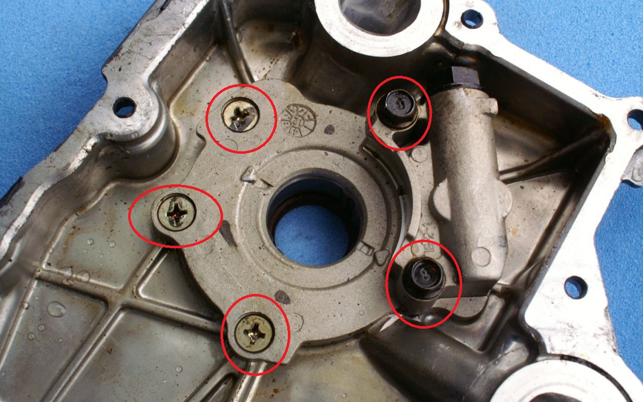 Выверните два болта, три винта крепления корпуса масляного насоса на автомобиле Hyundai Solaris