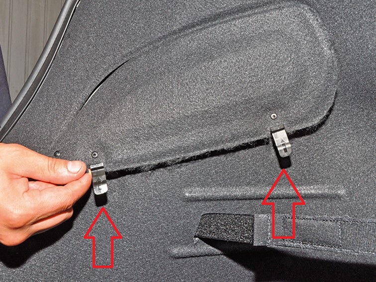 Отстегнуть фиксаторы крышки технологического отверстия в боковой облицовке багажника на автомобиле Hyundai Solaris