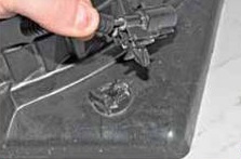 Выводим фиксатор колодки из отверстия в кожухе на автомобиле Лада Гранта