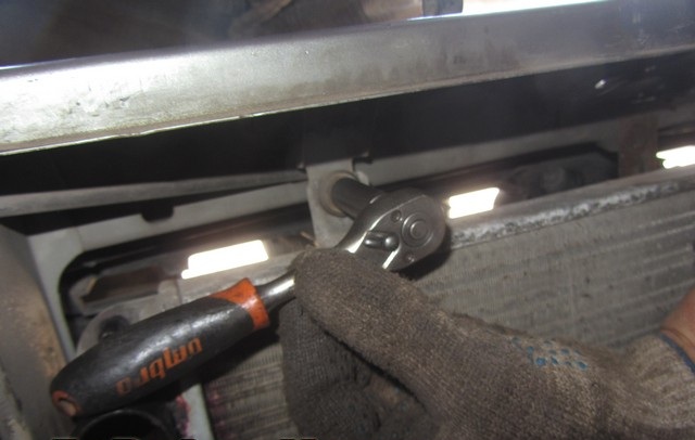 Откручивание левой гайки крепления радиатора к верхней поперечине рамки радиатора Лада Гранта (ВАЗ 2190)