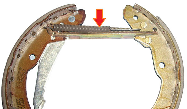 Установка верхней стяжной пружины барабанного тормозного механизма заднего колеса автомобиля Skoda Fabia I